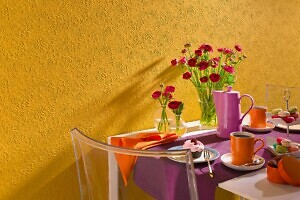 Gelbe Wand hinter gedecktem Tisch