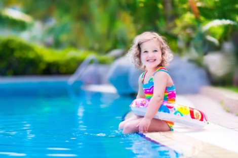 Mädchen sitzt am Pool