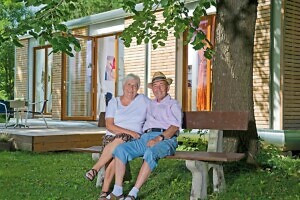 Ehepaar sitzt auf Bank vor Zuhause